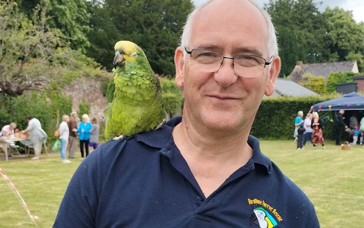 Funeral director Mark and his green parrot Charlie.
